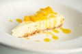 White plate with a freshly-baked piece of cheesecake, garnished with cut orange slices Royalty Free Stock Photo