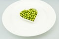 The white plate, a heart-shaped small, fresh peas