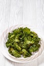 White plate with kale chips on the table Royalty Free Stock Photo