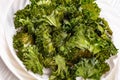 White plate with kale chips on the table Royalty Free Stock Photo