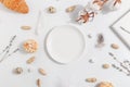 White plate on a light background. Composition with lavender, cotton and nuts