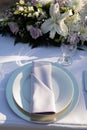 White plate with light violet napkin, clearwine glass and florals - lilis, roses and chrysanthemum. Wedding reception table