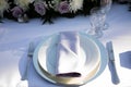 White plate with light violet napkin, clearwine glass and florals - lilis, roses and chrysanthemum. Wedding reception table Royalty Free Stock Photo