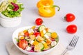 White plate with mix vegetable salad, greens, crackers and sesame seeds on a light background Royalty Free Stock Photo