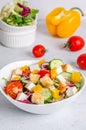 White plate with mix vegetable salad, greens, crackers and sesame seeds on a light background. Royalty Free Stock Photo