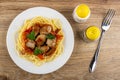 Plate with fried pork meat with lecho and spaghetti, salt and pepper, fork on wooden table. Top view Royalty Free Stock Photo