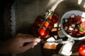 White plate with pomade salad, feta cheese and basil. Hand with knife cuts cheese. Royalty Free Stock Photo