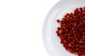 In a white plate are pomegranate seeds