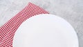 White plate with red cloth on dining table