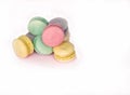 On a white plate are round French cookies, green, yellow, pink, purple in different colors. For advertising confectioners, bakers,