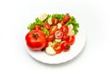 White plate of salad with vegetables on white background. Top view. Tomato, pepper, salad, garlic