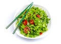 White plate of salad with vegetables isolated on white background. Wooden chopsticks for food Royalty Free Stock Photo