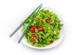 White plate of salad with vegetables isolated on white background. Wooden chopsticks for food Royalty Free Stock Photo