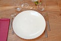 White plate with set of silverware on Brown wooden table Royalty Free Stock Photo