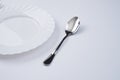 A white plate with silver fork and spoon isolated on white background with copy space. Dinner place setting. Table Setting. Royalty Free Stock Photo