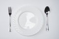 A white plate with silver fork and spoon isolated on white background with copy space. Dinner place setting. Table Setting. Royalty Free Stock Photo