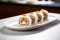 white plate with a single sushi roll sliced and standing upright Royalty Free Stock Photo