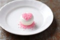 a white plate with a single tiny pink cupcake Royalty Free Stock Photo