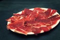 White plate with slices of Serrano ham. Typical Spanish Royalty Free Stock Photo