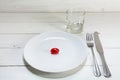 White plate with a small red easter egg, knife, fork and drinki Royalty Free Stock Photo