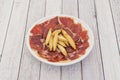 White plate with thin slices of acorn-fed Iberian ham with country spikes Royalty Free Stock Photo