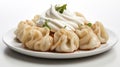 A white plate topped with manti dumplings and whipped cream, traditional Turkish dish.