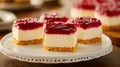A white plate topped with mini cheesecakes covered in raspberry jam Royalty Free Stock Photo