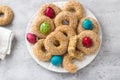 White plate with traditional Greek Easter cookies Koulourakya or Koulourya shortbread rings with sesame seeds, decorated with