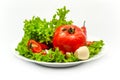 White plate with vegetables isolated on white background. Front view. Tomato, pepper, salad,garlic