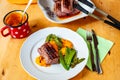 White plate with venison steak, pumpkin puree, pea pods, pot with pumpkin, steaks in bowl Royalty Free Stock Photo