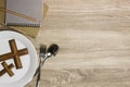 A white plate with a wooden cross and Bible over the wooden table. Royalty Free Stock Photo