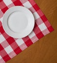 White plate on wooden table with red tablecloth