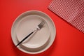 White plates, fork, napkin on red background. Royalty Free Stock Photo