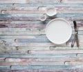 White plates and vintage spoons and fork on color wooden background Royalty Free Stock Photo