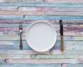 White plates and vintage spoons and fork on color wooden background Royalty Free Stock Photo