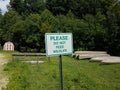 White please do not feed wildlife sign with shed and boats or canoes Royalty Free Stock Photo