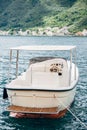 White pleasure boat with awning, rear view. Moored in the water.