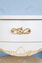 White polished chest of drawers with golden handles. Luxurious chest of drawers in a classic style. Vertical photography Royalty Free Stock Photo