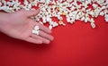 White popcorn on a red background.  hand holding Pop corn Royalty Free Stock Photo