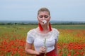 White poppy flower in the hands of a girl in the middle of a field of red poppies Royalty Free Stock Photo