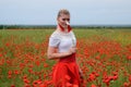 White poppy flower in the hands of a girl in the middle of a field of red poppies Royalty Free Stock Photo