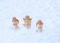 Three angel figures who pray on a white cloud with wings, with wreaths on their heads.