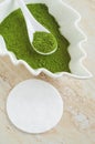 White porcelain bowl with matcha green tea powder henna, seaweed and cotton pad. Natural beauty treatment and spa. Royalty Free Stock Photo