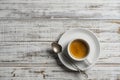 White porcelain coffee cup with saucer and spoon over wooden background, top view, copy space, closeup. Hot espresso coffee in a Royalty Free Stock Photo