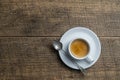 White porcelain coffee cup with saucer and spoon over wooden background, top view, copy space, closeup. Hot espresso coffee in a Royalty Free Stock Photo