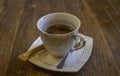 White porcelain cup with coffee and saucer on a wooden table Royalty Free Stock Photo