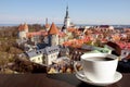 White porcelain cup of coffee or tea with view from above of red rooftops, historic old town and churches in Tallinn Royalty Free Stock Photo