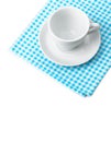 White porcelain mug with saucer tableware on cellular napkin Royalty Free Stock Photo