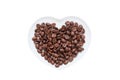 White porcelain plate in shape of heart with coffee beans. Isolated white background Royalty Free Stock Photo