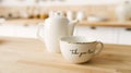 White porcelain tea cup and teapot, Afternoon tea table setting in white kitchen on wooden table